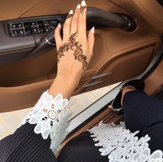 a woman's hand on the door handle of a car, with lace detailing