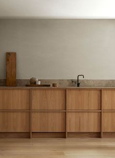 an empty kitchen with wooden cabinets and counter tops in the center, along with white walls