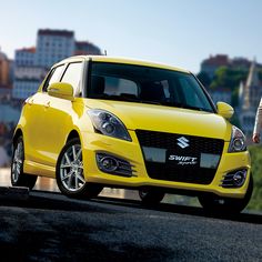 a man standing next to a yellow suzuki swift