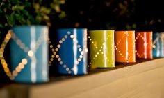 there are many colorful cups lined up on the shelf