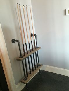 a rack that has some baseball bats on it and is leaning up against the wall