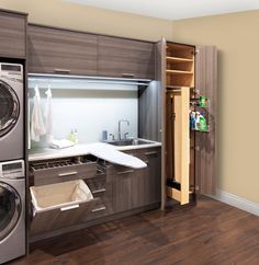 a washer and dryer in a room with wood flooring, built - in shelving