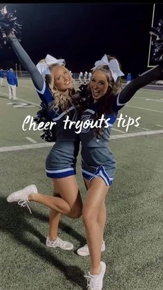 two cheerleaders are dancing on the football field