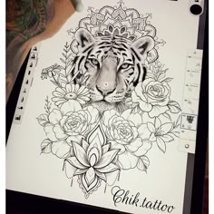 a tiger surrounded by flowers on top of a sheet of paper with the word ink tattoo