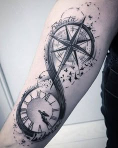 a man's arm with a compass tattoo on it