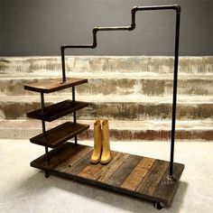 a pair of boots are sitting on a wooden shelf next to a set of stairs