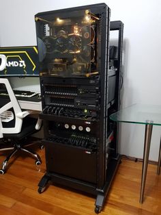 a computer tower sitting on top of a hard wood floor next to a glass table