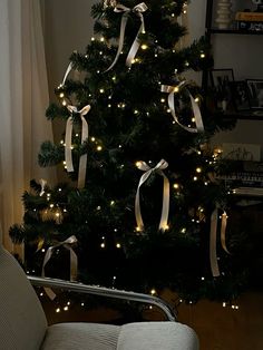 a decorated christmas tree with lights and ribbons