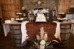 a wedding cake on top of a wooden barrel