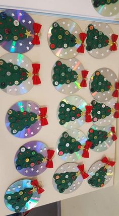 several cds are arranged in the shape of christmas trees with bows and ribbons on them