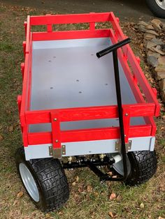 a red and white wagon sitting in the grass