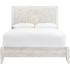 a white bed with an intricate headboard and foot board