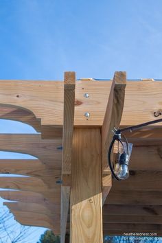 an outdoor lighting fixture attached to the side of a wooden structure under a blue sky