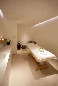 a white room with two beds in it and some lights on the wall behind them