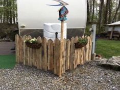 a wooden fence with two buckets on top and a water tank in the middle