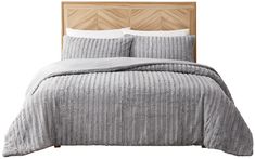 a bed with grey bedspread and pillows