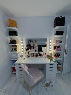 a white desk topped with lots of drawers next to a closet filled with bags and purses