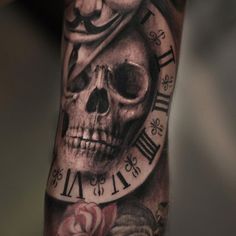 a man's arm with a clock and skull tattoo on it, including roses