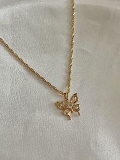 This beautiful butterfly necklace is made with a dazzling 18K gold plated butterfly pendant and chain. The necklace makes for an exquisite everyday accessory. The butterfly pendant features four sparkling crystals that elevate the look of the necklace.  With the perfect combination of comfortable, affordable, and quality, this necklace is sure to be an everyday  staple in your jewelry collection.  Length: 16inches.  Material: All findings, chain, and pendant are 18K Gold-Plated over brass.  Hand Gold Plated Butterfly Necklace, Gold-plated Gold Butterfly Necklace, Gold Plated Butterfly Necklace With Charm, Gold Plated Butterfly Pendant Necklace, Yellow Gold Butterfly Necklace With Butterfly Clasp, Butterfly Pendant Necklace, Everyday Accessories, Butterfly Necklace, Butterfly Pendant