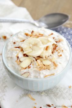 a bowl filled with oatmeal topped with banana slices and chopped almonds