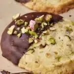 two cookies with chocolate frosting and sprinkles are on the table next to each other