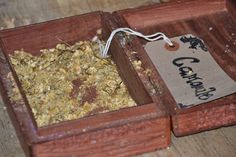 a wooden box filled with granola on top of a table next to a tag