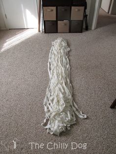 a pile of white yarn sitting on top of a carpeted floor next to a dresser