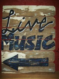 a wooden sign that says live music with an arrow pointing to the right and left