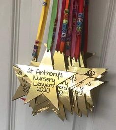 a gold star hanging from the side of a white door with ribbons attached to it