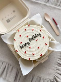 a birthday cake sitting on top of a white plate next to a fork and knife