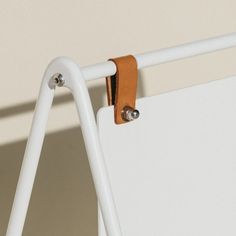 a close up of a white board with two clips attached to the back of it