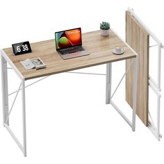 a laptop computer sitting on top of a wooden desk next to a white metal frame