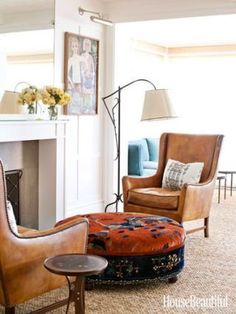 a living room filled with furniture and a fire place next to a mirror on the wall