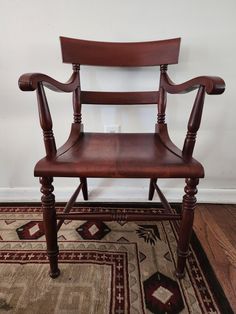 a wooden chair sitting on top of a rug