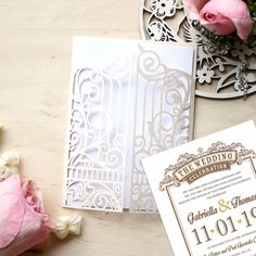 the wedding stationery is laid out on a table with flowers and paper cutouts