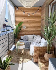 a small balcony with wicker furniture and potted plants