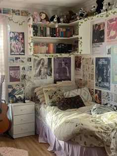 a bed room with a neatly made bed and lots of posters on the wall above it