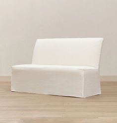 a white couch sitting on top of a hard wood floor