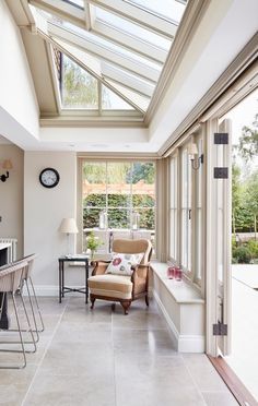 a living room filled with furniture and a skylight over the kitchen counter top next to a bar