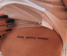 a woman's back with the words live every moment written on it