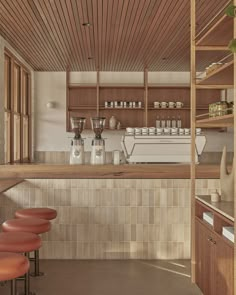 an empty bar with stools in front of it and shelves on the wall above