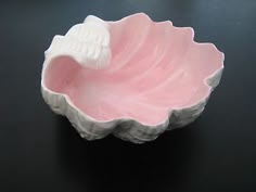 a pink bowl sitting on top of a black table