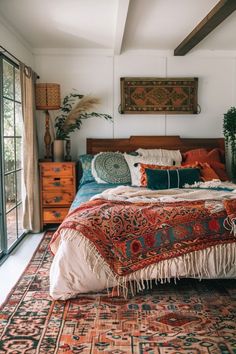 a bedroom with a bed, dressers and rug on the floor in front of glass doors