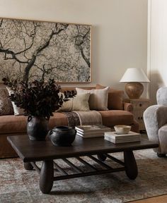 a living room with two couches and a coffee table in front of a painting