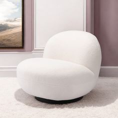 a white chair sitting on top of a rug in front of a wall mounted painting