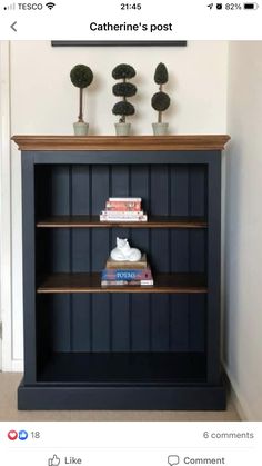 a book shelf with books on top of it and two vases above the shelves