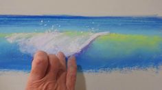 someone is painting a wave on the wall with blue and green paint, while holding their hand