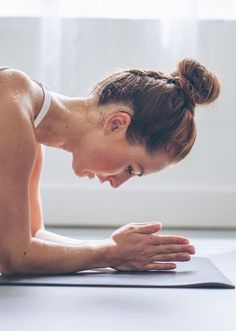 a woman doing push ups on a yoga mat