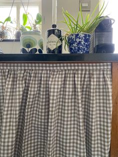 a kitchen counter with some plants on top of it and a window in the background