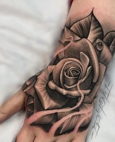 a hand with a rose tattoo on it